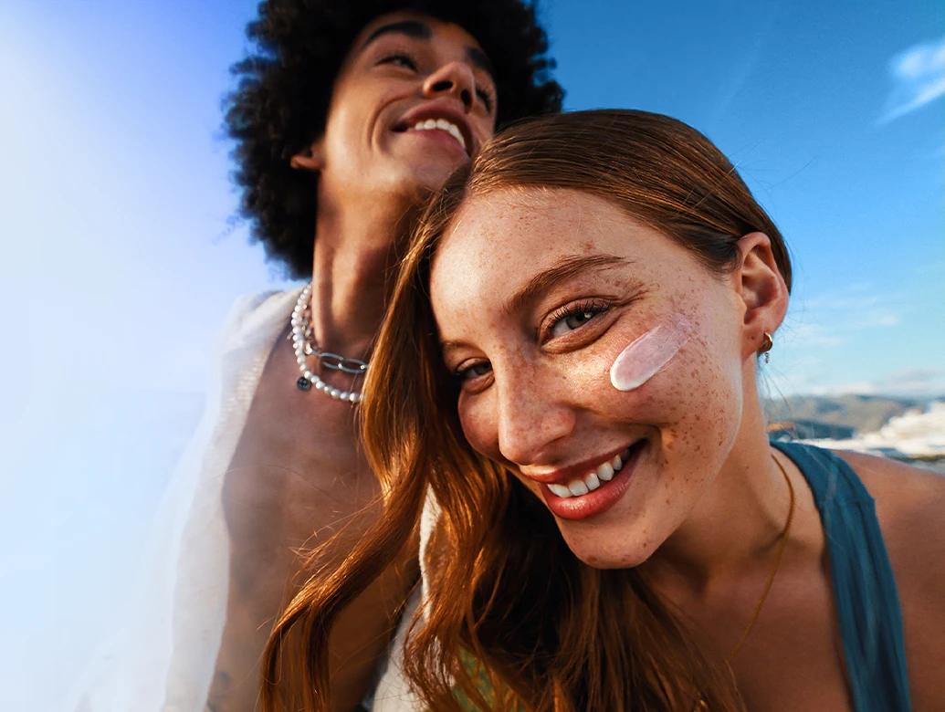 In the image, two people are standing close to each other, smiling and enjoying their time together. The woman is posing for a selfie, and the man is standing behind her, looking at the camera. (photo)