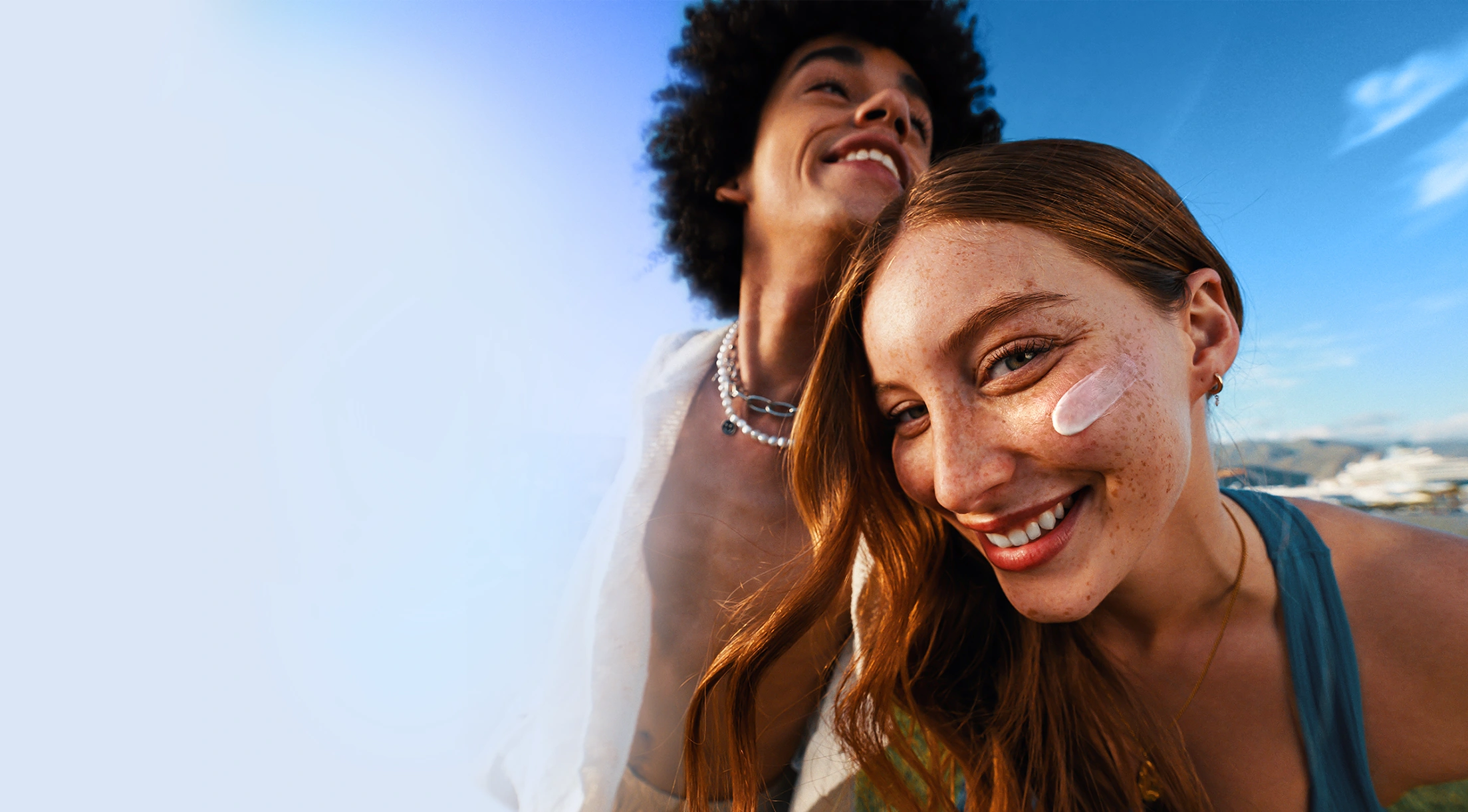 In the image, two people are standing close to each other, smiling and enjoying their time together. The woman is posing for a selfie, and the man is standing behind her, looking at the camera. (photo)