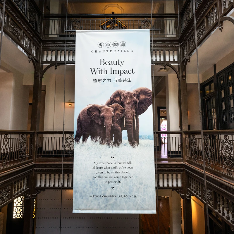 In this image, there is a large banner hanging from a ceiling, promoting beauty with impactful words. The banner is positioned above a staircase, drawing attention to its message. (photo)